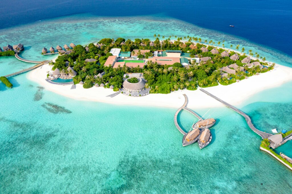 Aerial view of a serene tropical island resort surrounded by crystal-clear waters.
