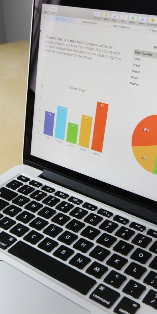 Laptop displaying charts and graphs with tablet calendar for data analysis and planning.